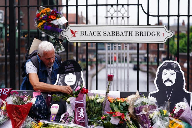 Floral tributes are left on the Black Sabbath Bridge bench on Broad Street in Birmingham (Jacob King/PA)