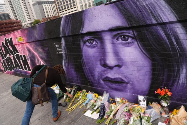 <p>Floral tributes are left by the Sabbath Wall on Navigation Street in Birmingham</p>