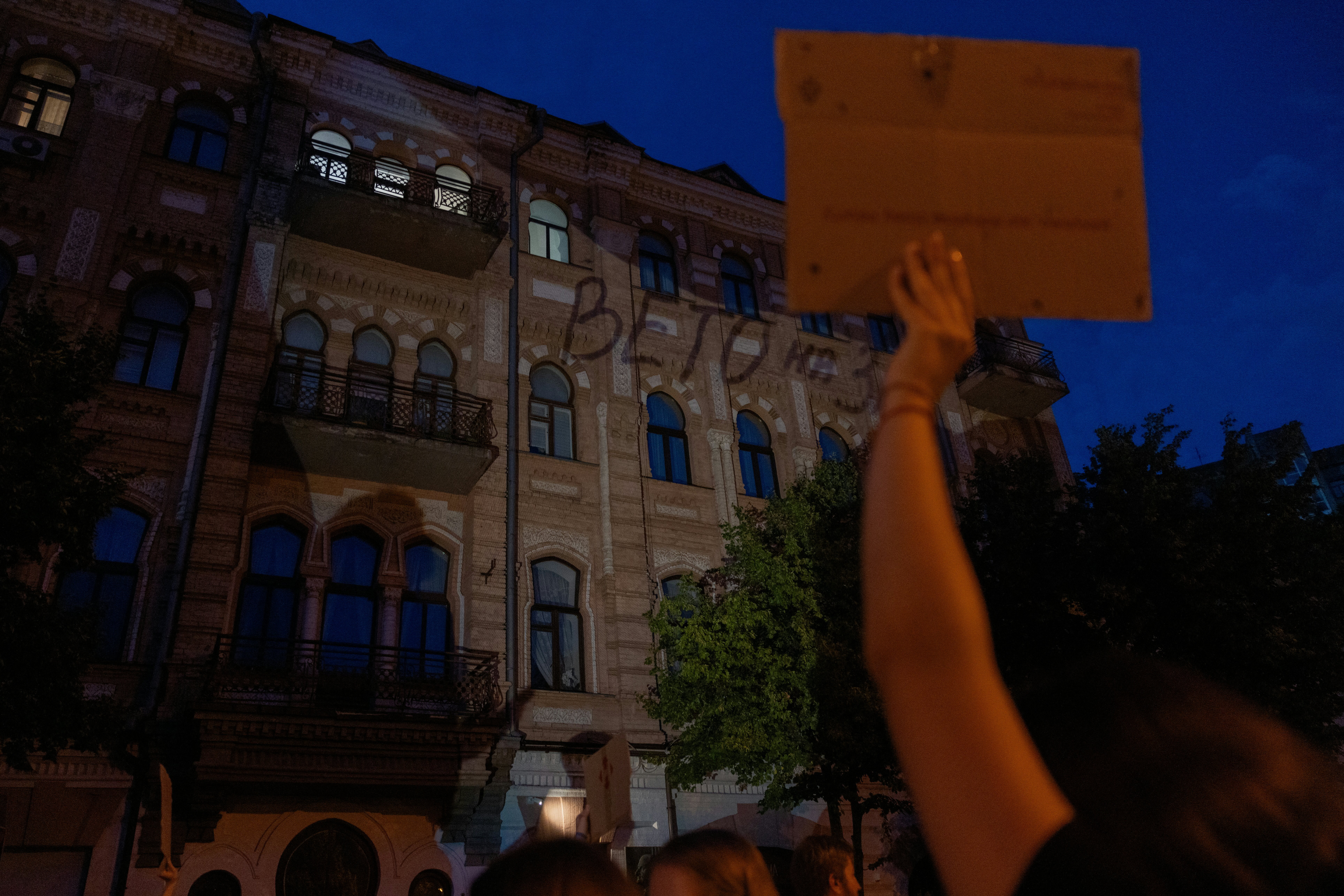 This photograph shows a projection reading ‘Veto the law’ on a building facade during a demonstration calling for the Ukrainian president to veto a law