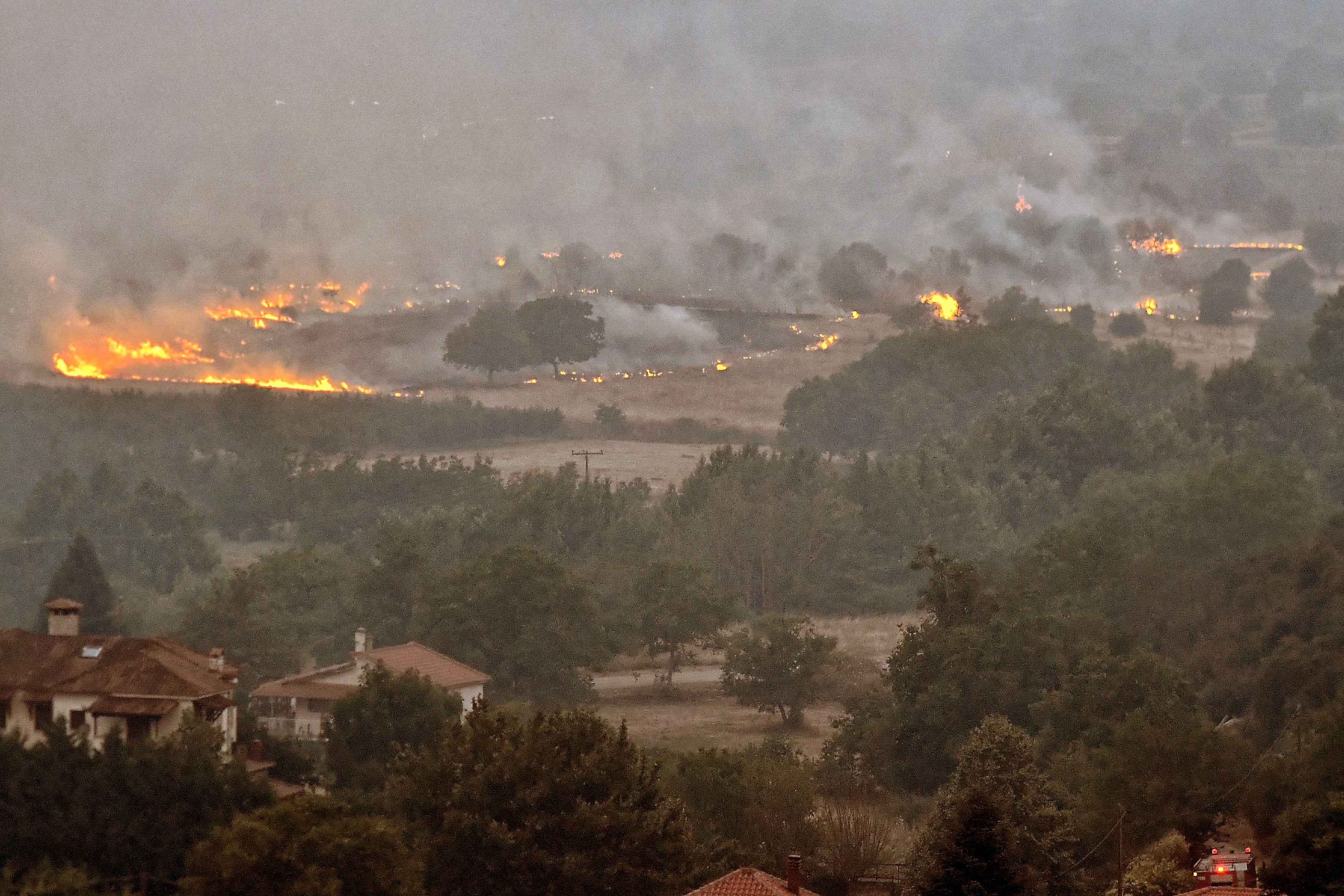 Flames rise as a wildfire burns next to the village of Karteri, in Feneos area