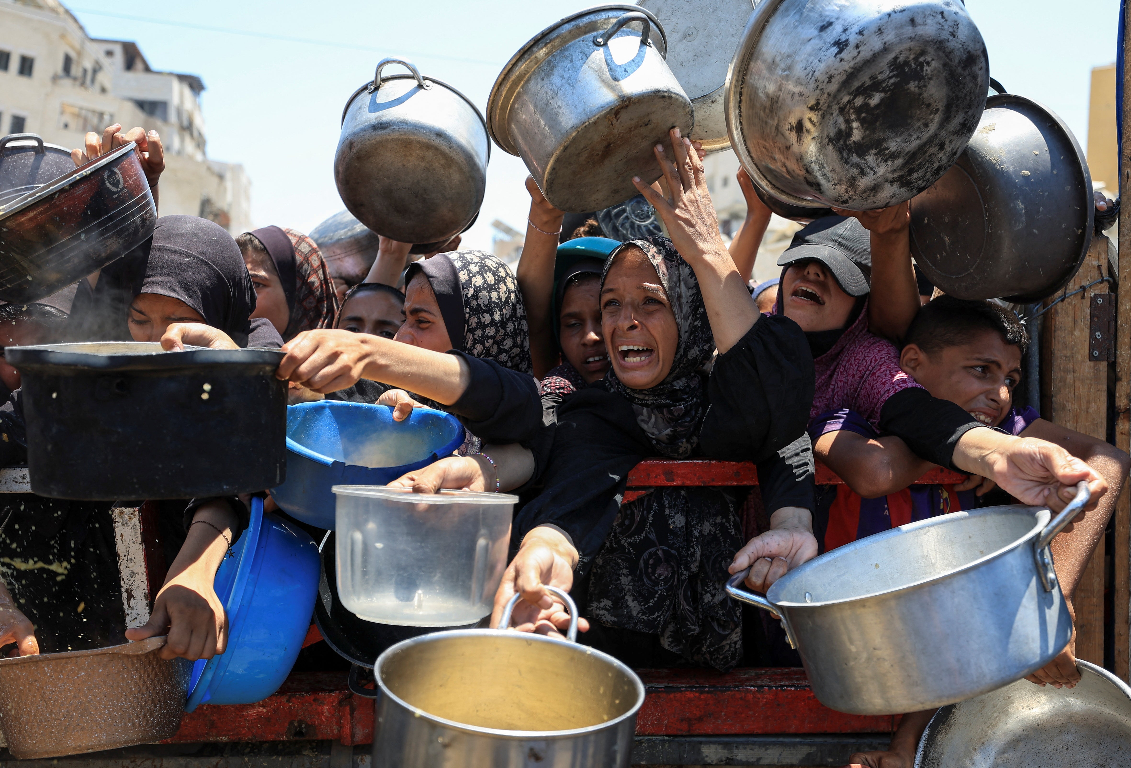 Palestinians gather to receive food from a charity kitchen, amid a hunger crisis, in Gaza City