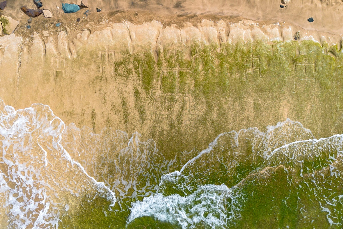Early Hawaiian petroglyphs on a beach are visible again with changing tides and shifting sands
