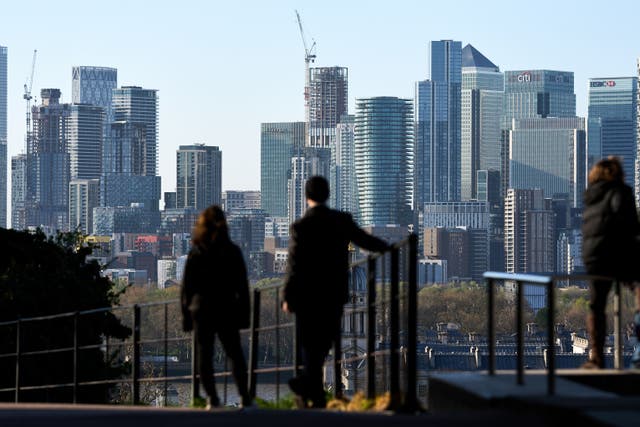 Visitors to Greenwich Park, London look out towards Canary Wharf (John Walton/PA)