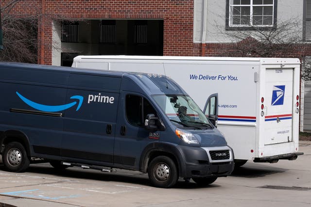 <p>An Amazon Prime truck and a U.S. Postal Service truck make deliveries at an apartment complex in Pittsburgh</p>