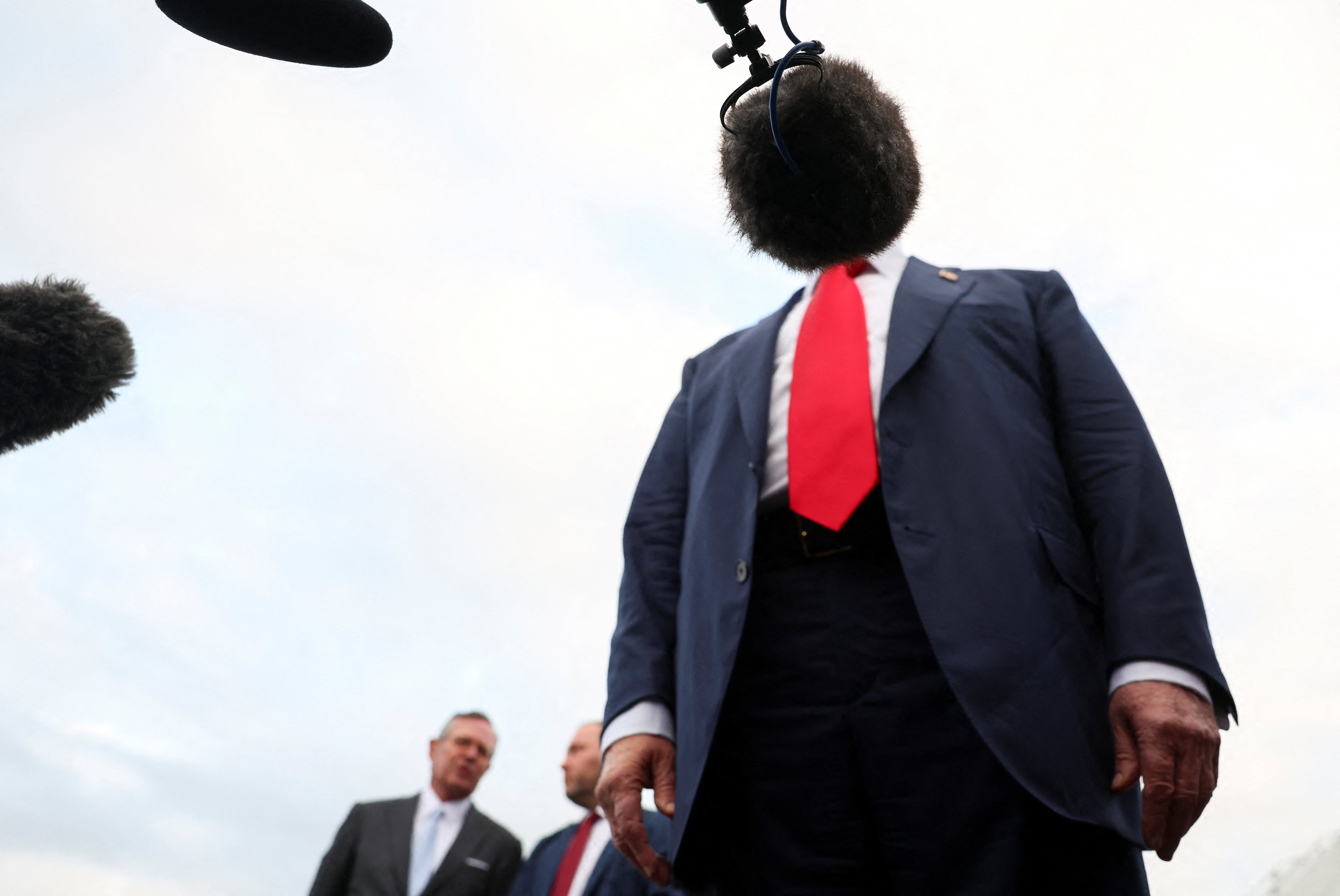 A microphone covers U.S. President Donald Trump's face as he speaks to members of the media on his arrival at Glasgow Prestwick Airport on July 25, 2025