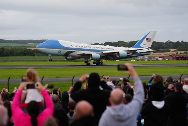 People watch as Air Force One carrying US President Donald Trump arrives at Prestwick Airport in Scotland (Jane Barlow/PA)