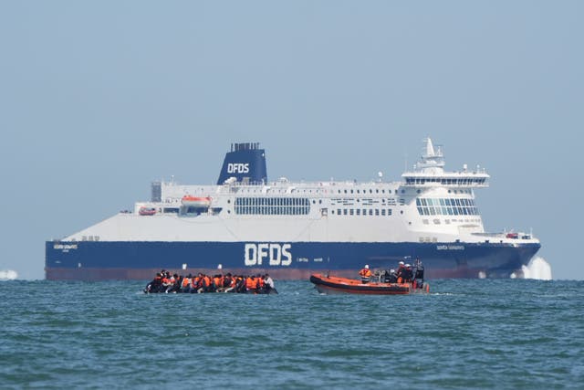 A boat intercepts people thought to be migrants on board an RIB (rigid inflatable boat) as it passes by the DFDS ferry Dover Seaways in the English Channel off the coast of Calais, France (Gareth Fuller/PA)