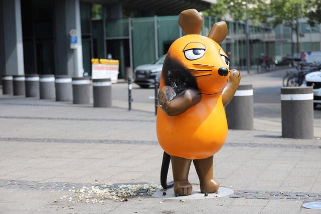 <p>A mouse statue that has been set on fire stands in front of the WDR (West German Broadcasting Corporation) building in Cologne, Germany, Saturday, July 26, 2025. (Sascha Thelen/dpa via AP)</p>