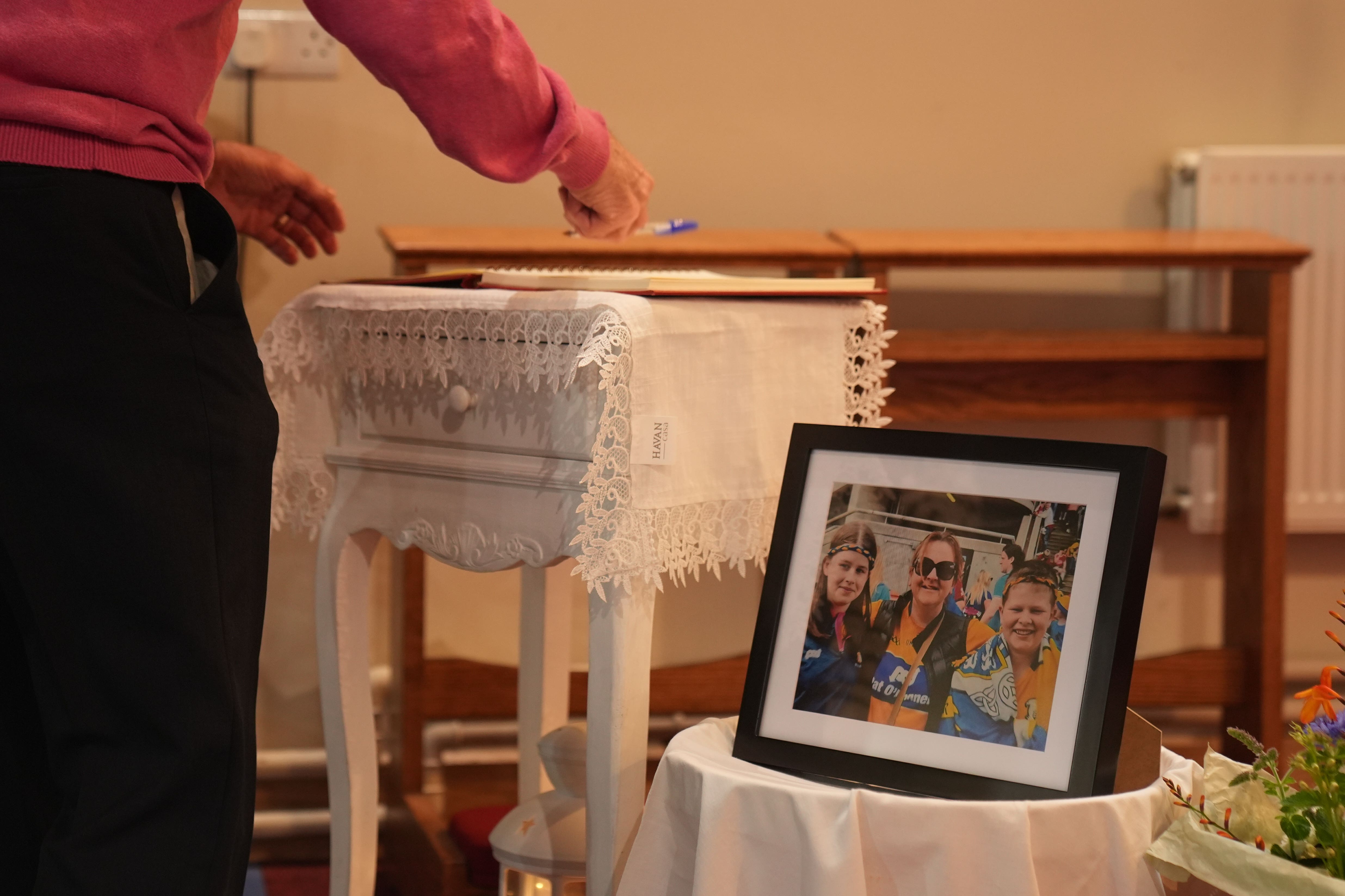 People sign a book of condolences during a prayer service at the Church of the Immaculate Conception (PA)