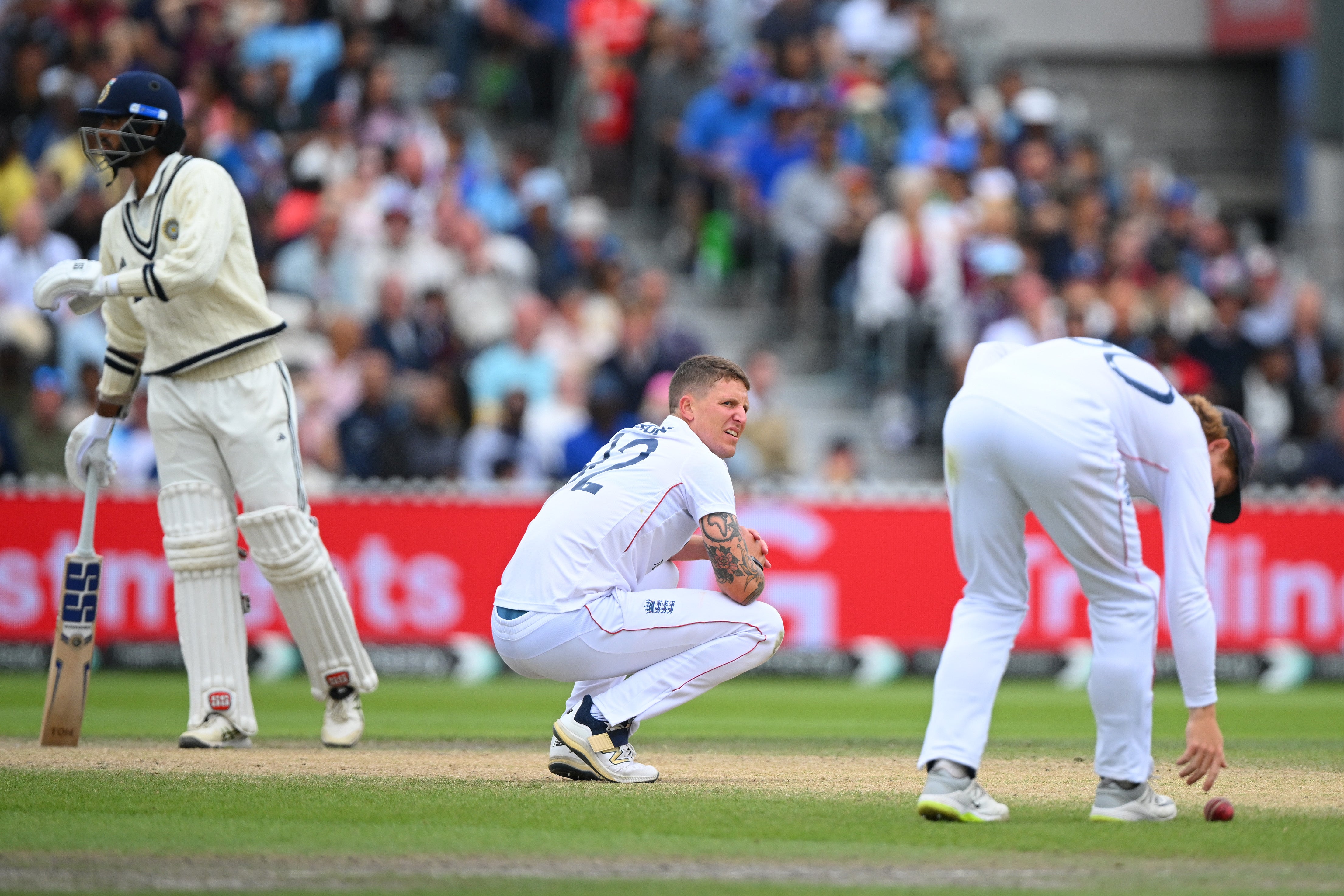 Brydon Carse of England gets down on his haunches as Ollie Pope retrieves the ball during Day Five