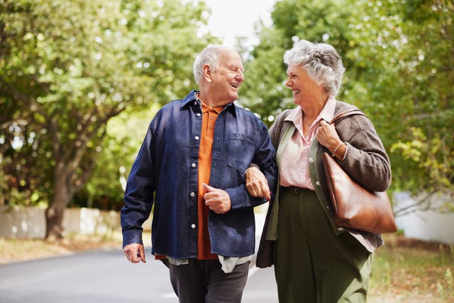<p>Smiling senior couple strolling together outside </p>
