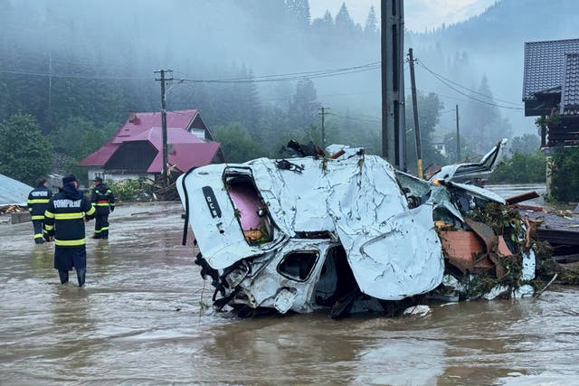 <p>In this image released by the Romanian Emergency Services Suceava (ISU Suceava) first responders walk by damaged vehicles after a flash flood in the village of Brosteni, northern Romania, Monday, July 28, 2025. (Romanian Emergency Services - ISU Suceava via AP)</p>