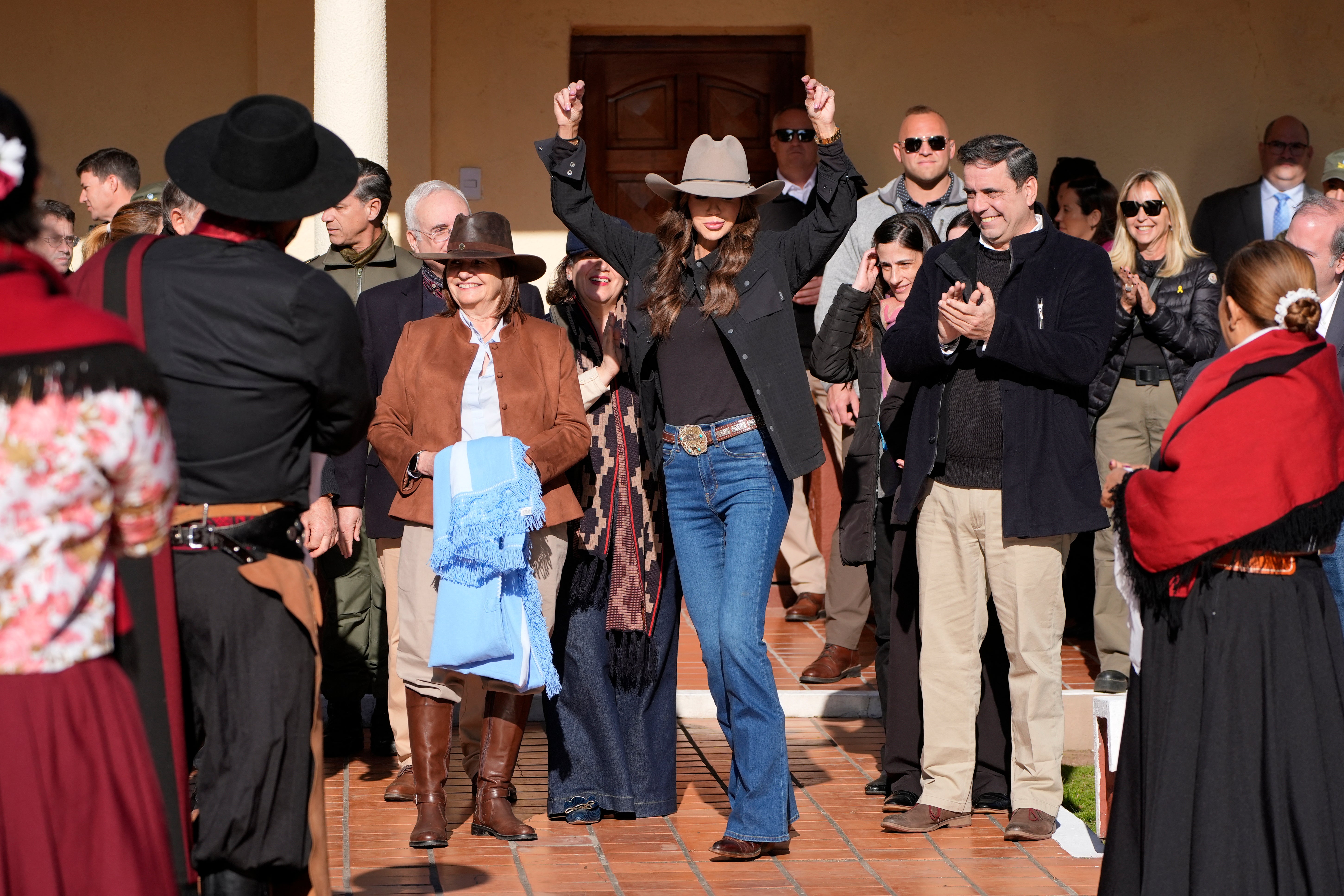 Noem strikes a dance pose next to Argentina's security minister Patricia Bullrich (left), after watching a traditional dance performance