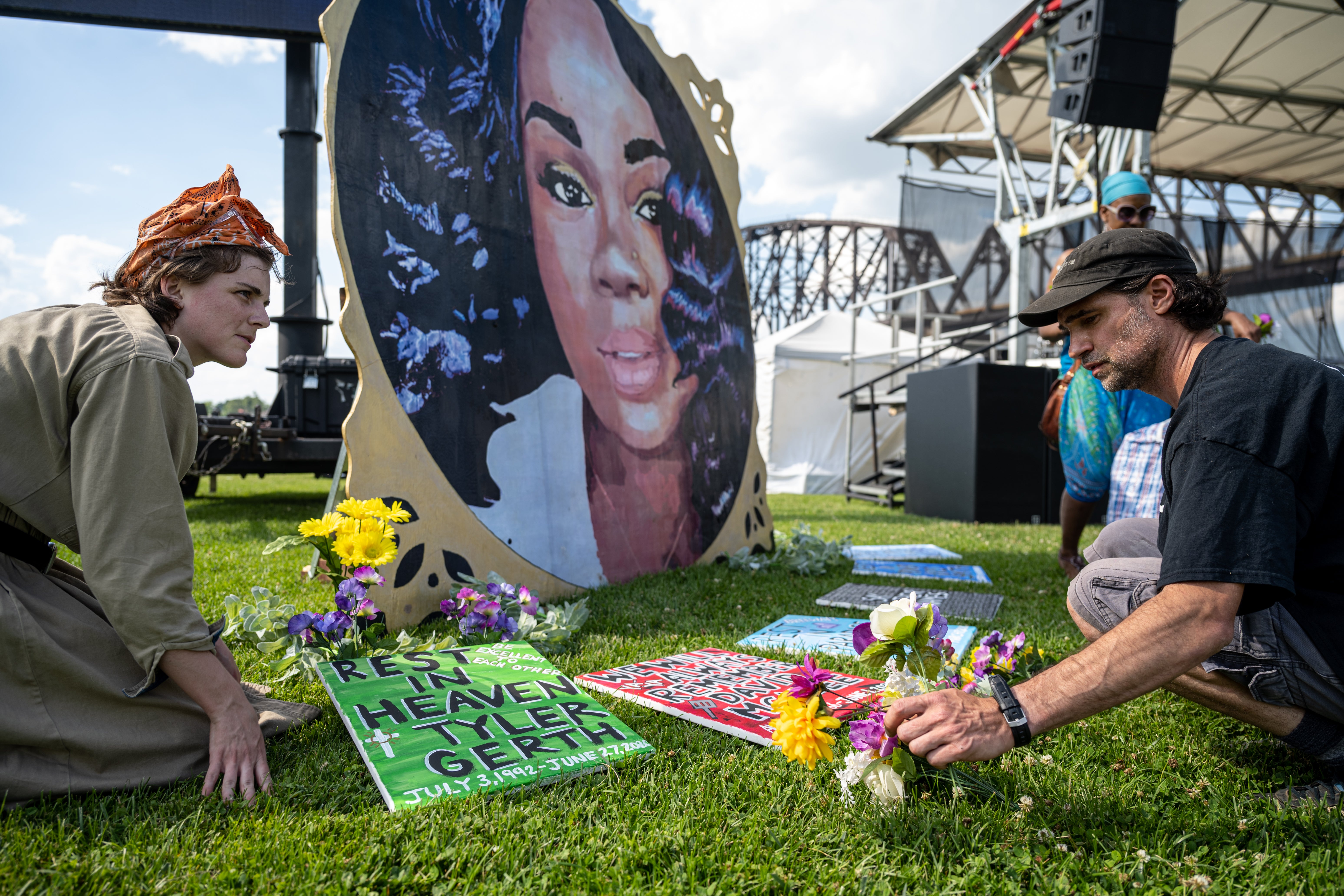 Protesters and volunteers prepare an art installation for Breonna Taylor, who was killed by police in her home, by laying posters and flowers at the Big Four Lawn on June 5, 2021, in Louisville, Kentucky
