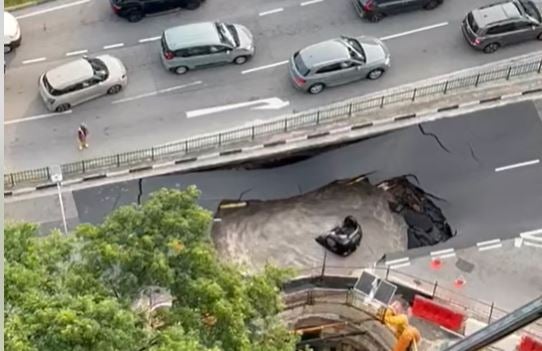 <p>A large sinkhole engulfed a black Mazda over the weekend in Singapore</p>
