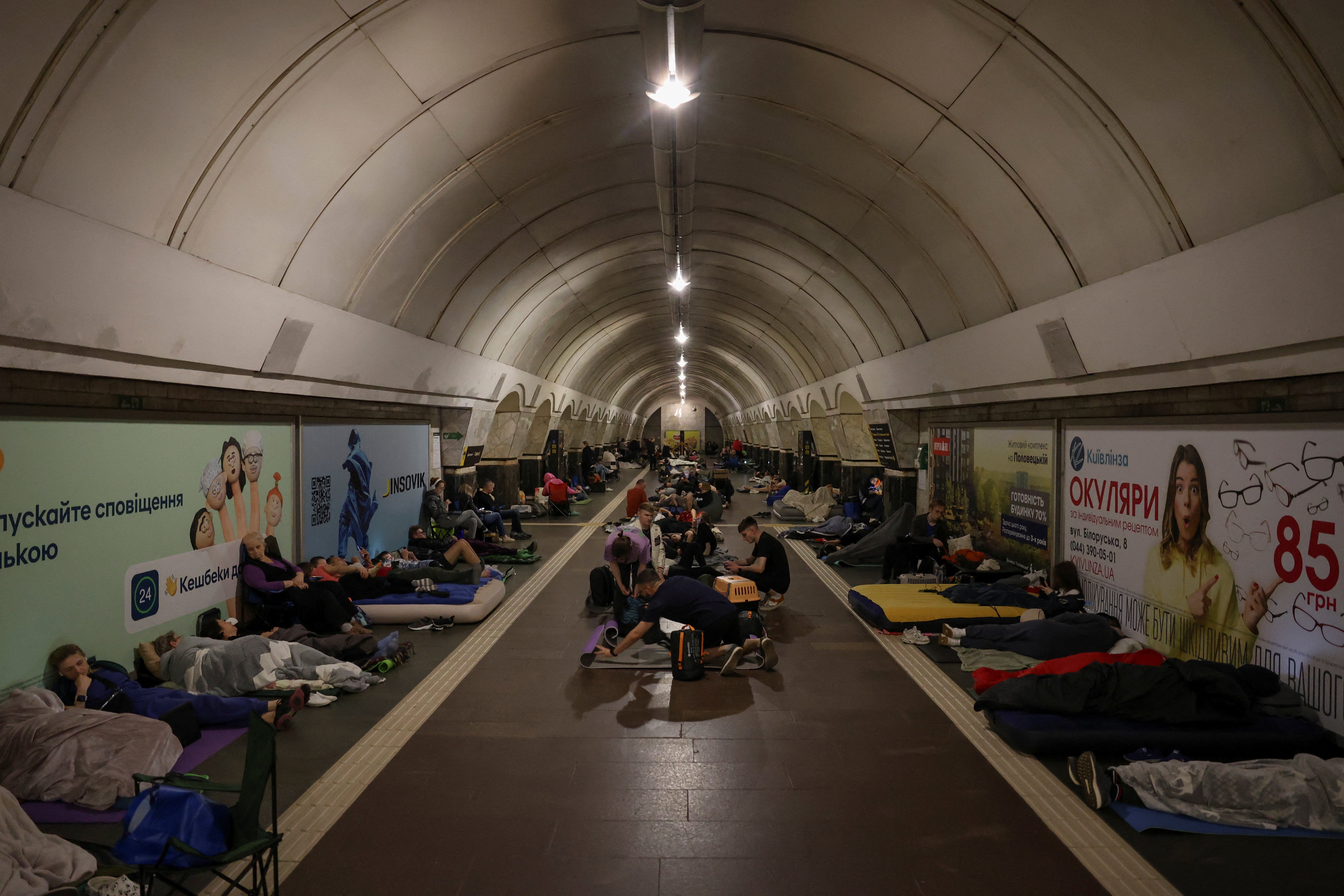 People take shelter inside a metro station during a Russian drone strike