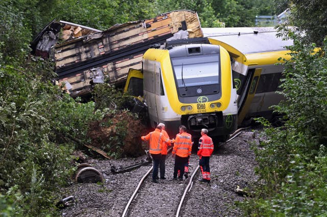 <p>Members of the German Railways Deutsche Bahn stand at the site where a local passenger train derailed causing several casualties, in Riedlingen near Biberach</p>