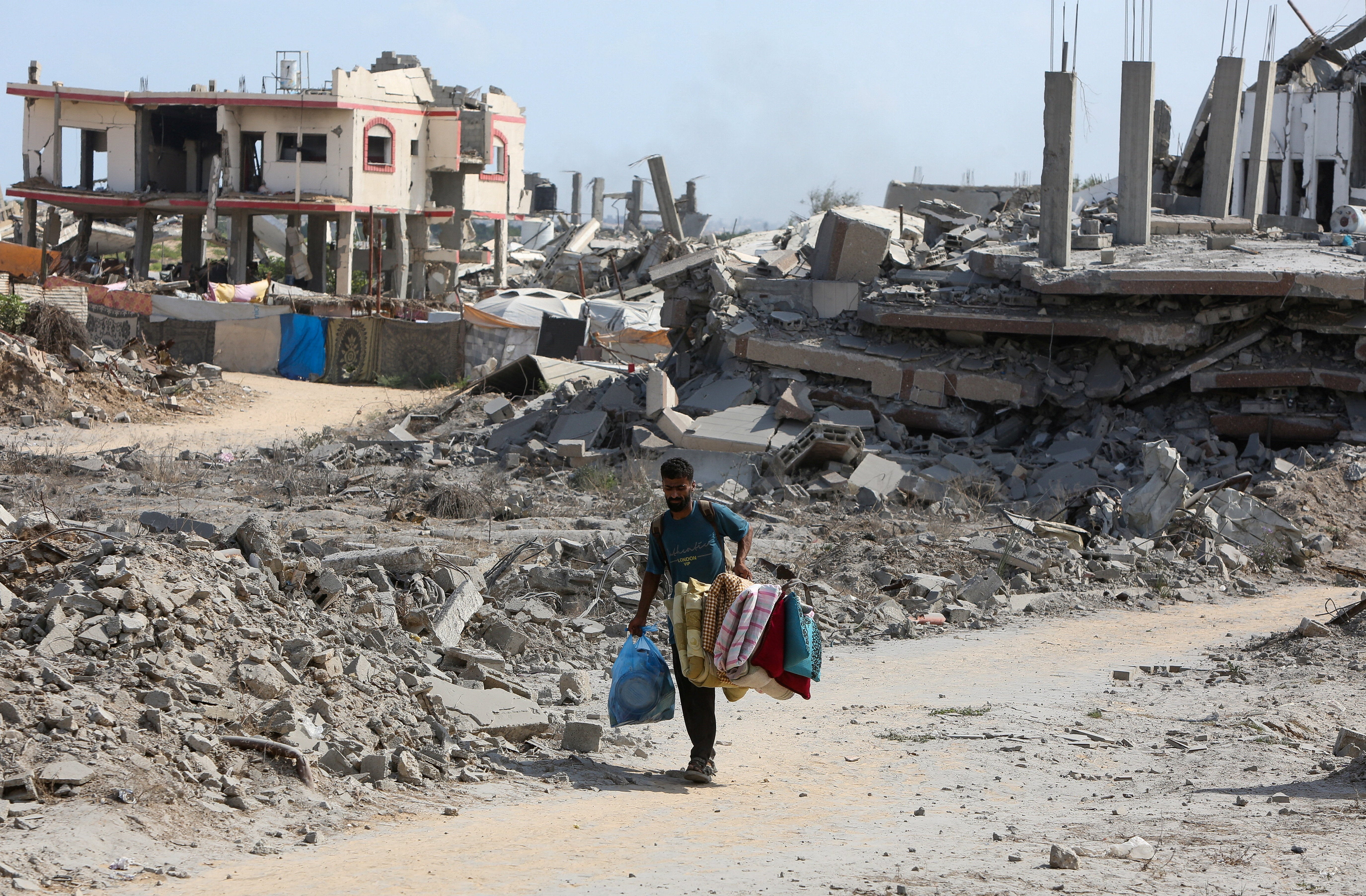 A Palestinian man walks near the rubble of houses destroyed during an Israeli raid