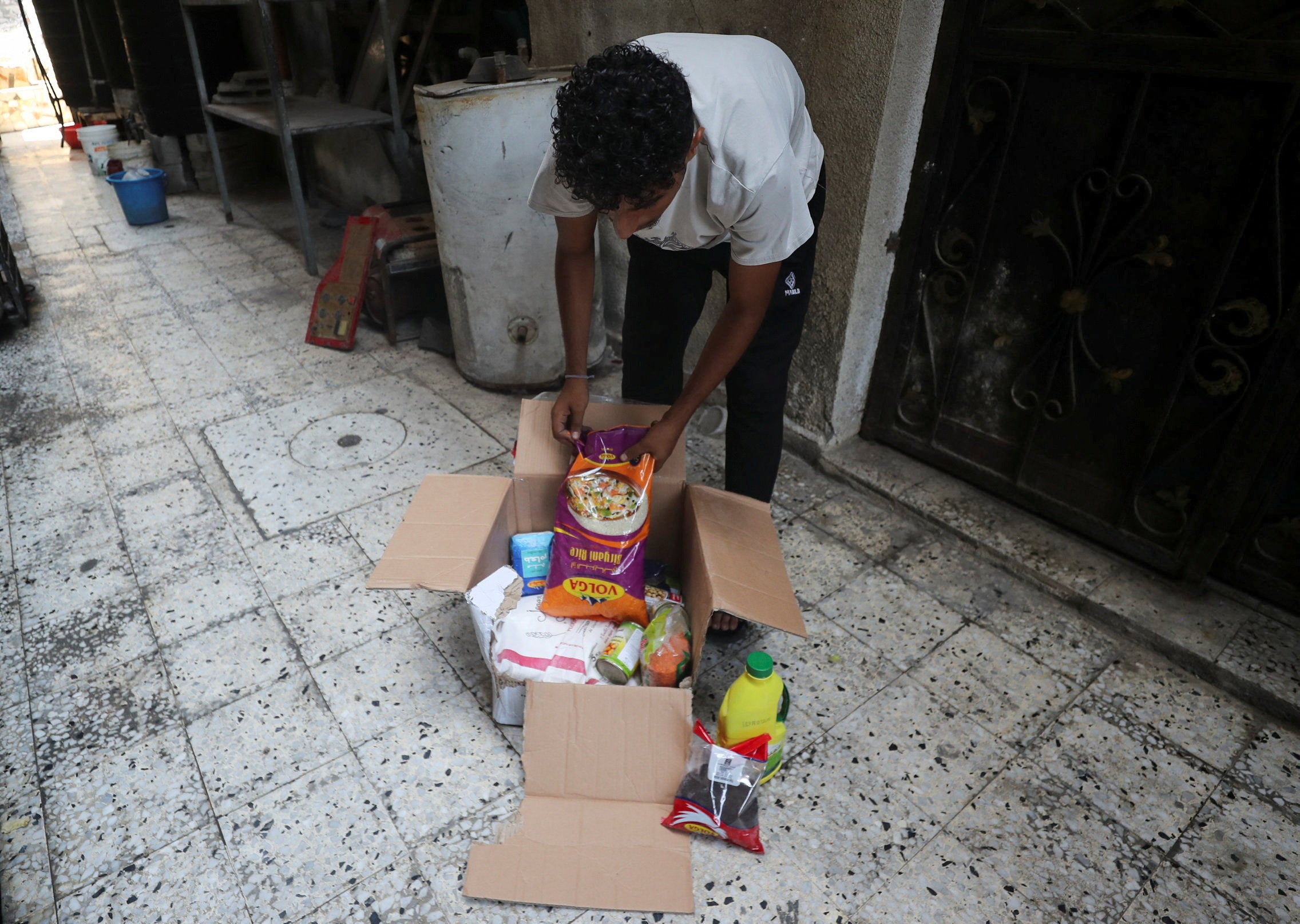 Mohammed Aboul Eineen, a displaced Palestinian man, displays the contents of an airdropped food parcel that he received, in Gaza City
