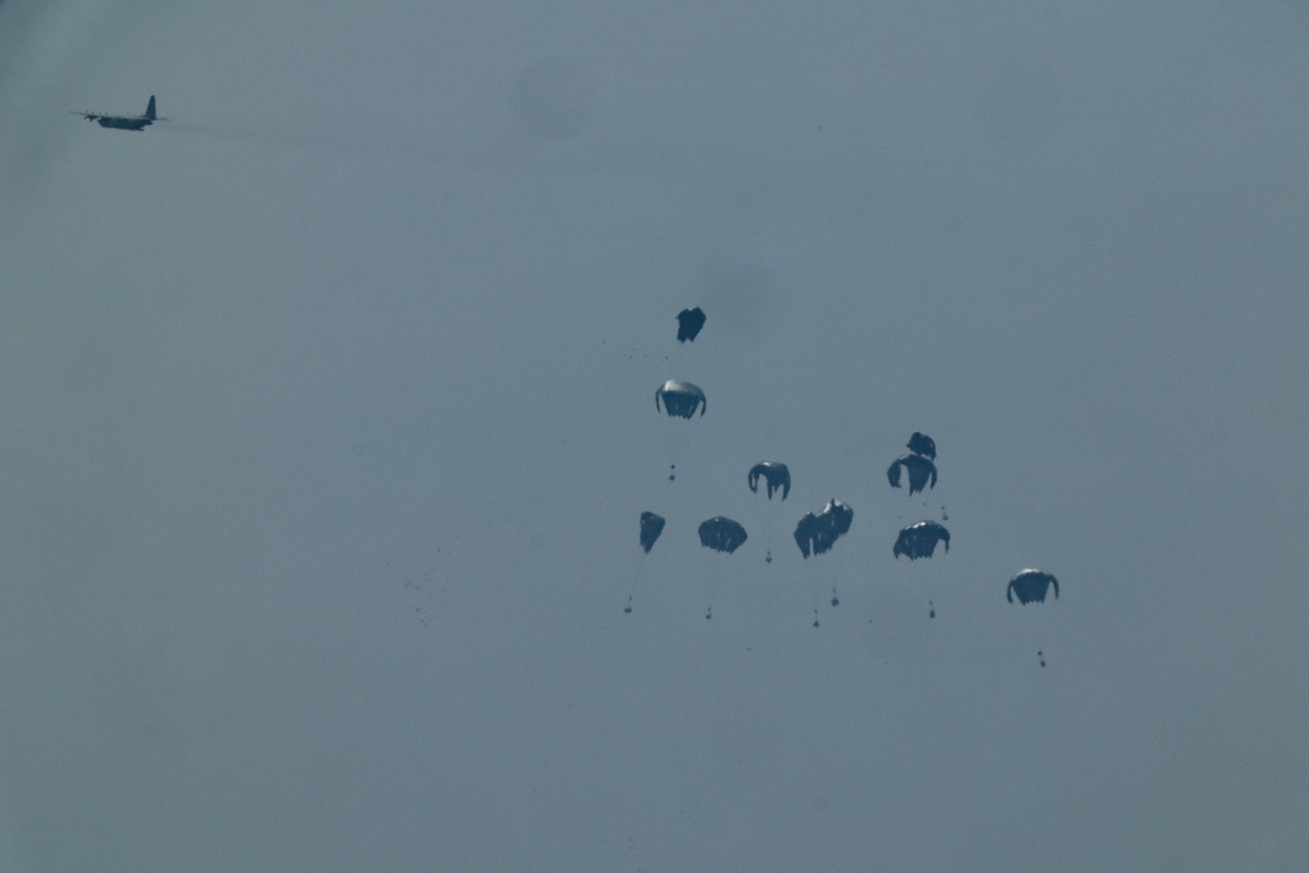 An aircraft drops humanitarian aid packages over the Gaza Strip, as seen from Israel