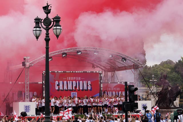 Red and white smoke fills the air as England’s players celebrate on stage (Gareth Fuller/PA)