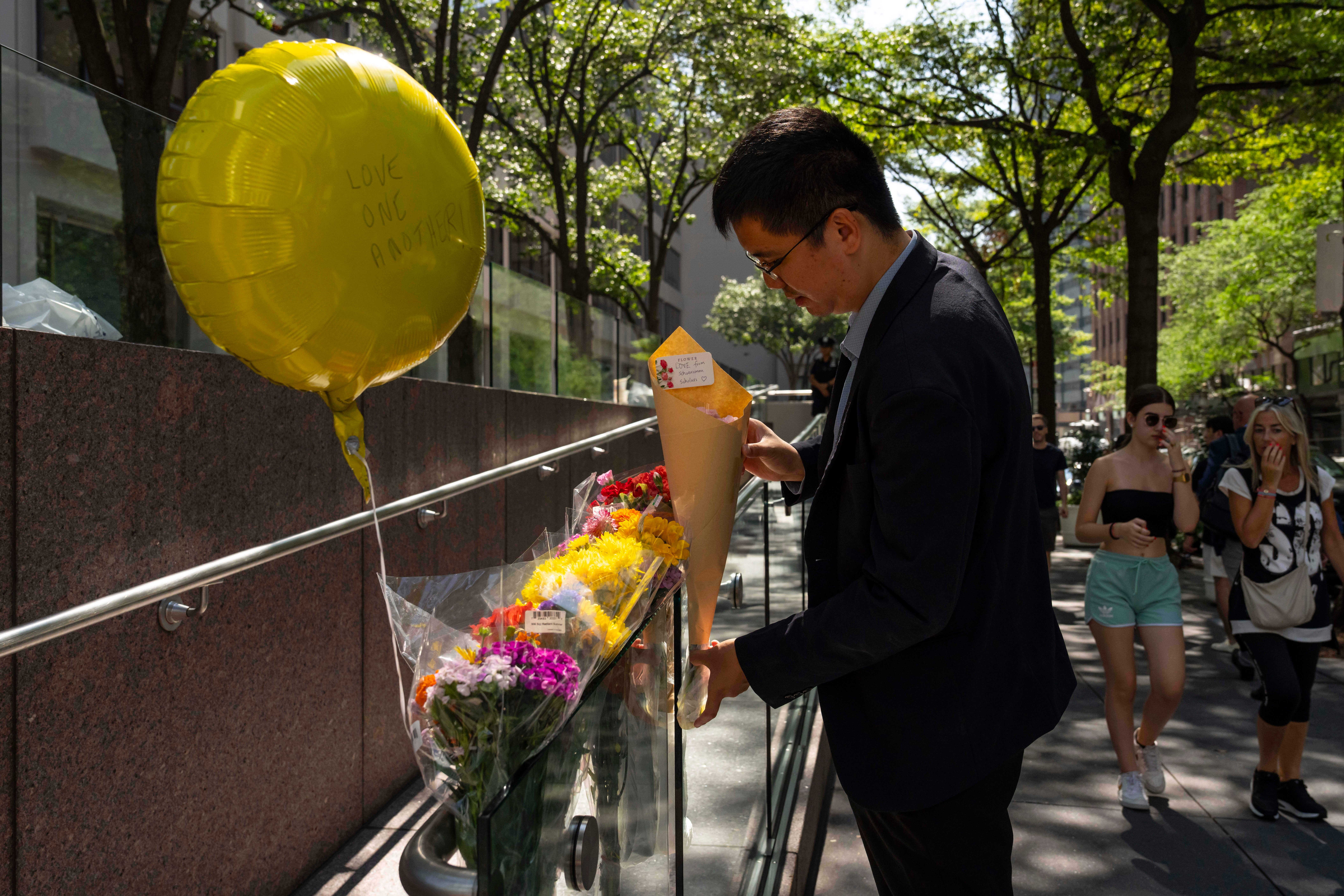 New Yorkers leave flowers at a makeshift memorial following the shooting.