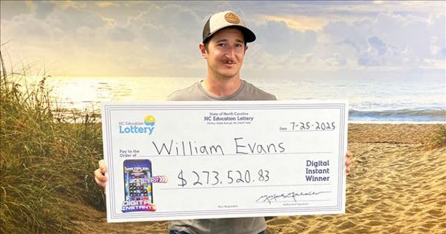 <p>William Evans holding his check after winning $274,520 in a digital lottery game</p>