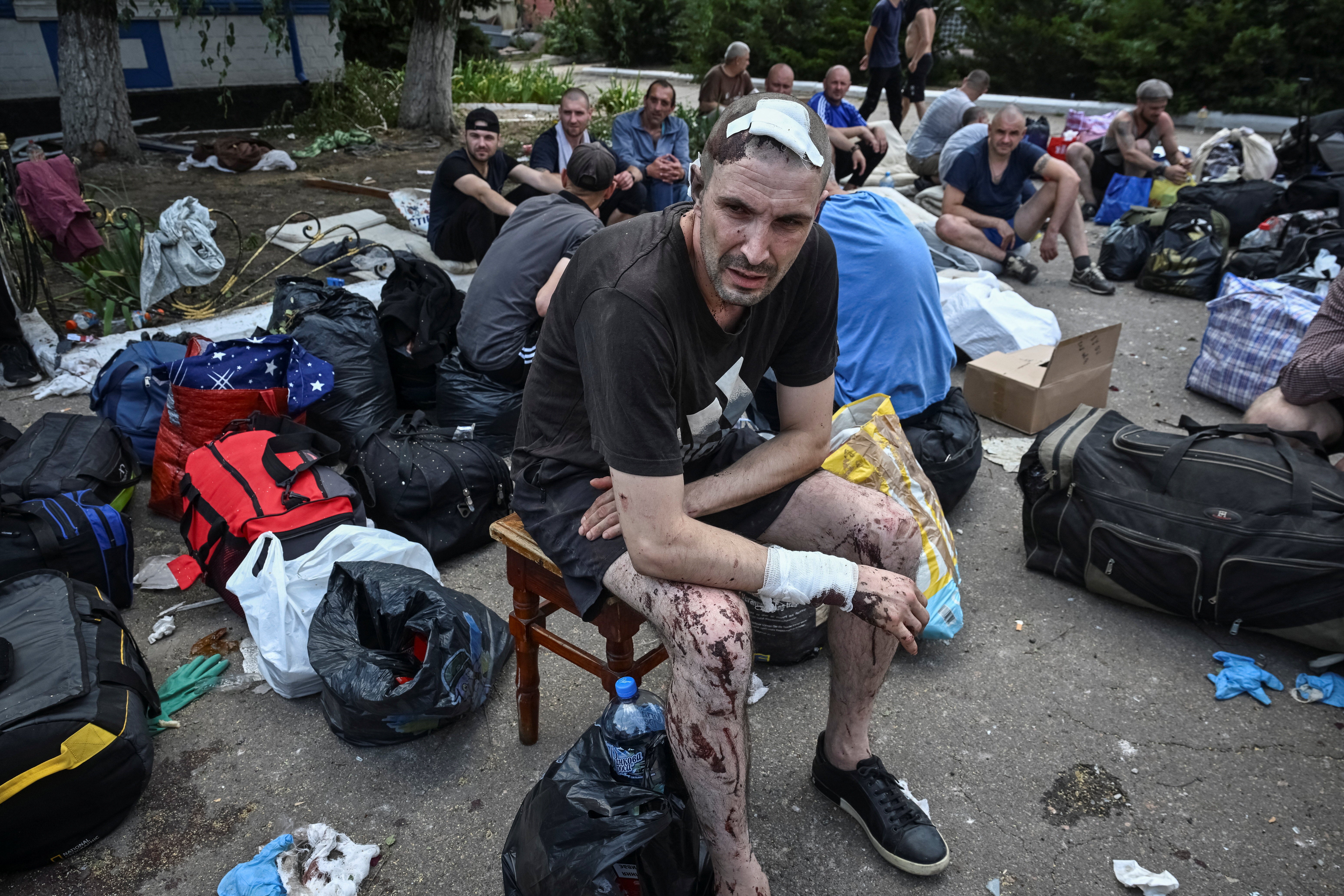 A wounded prisoner sits at the site of the jail
