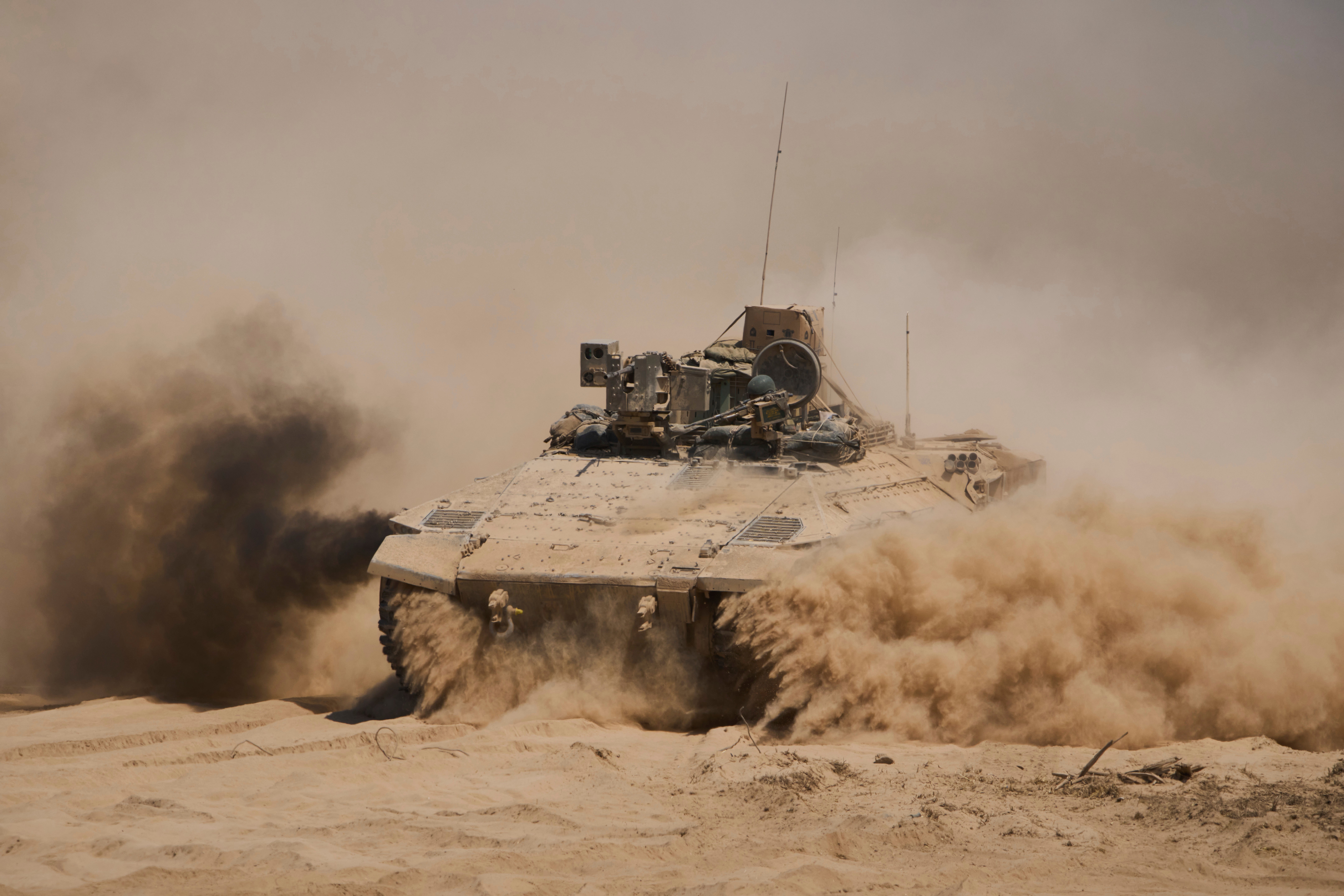 Israeli soldiers drive on their armoured personnel carrier back from inside the northern Gaza Strip into southern Israel