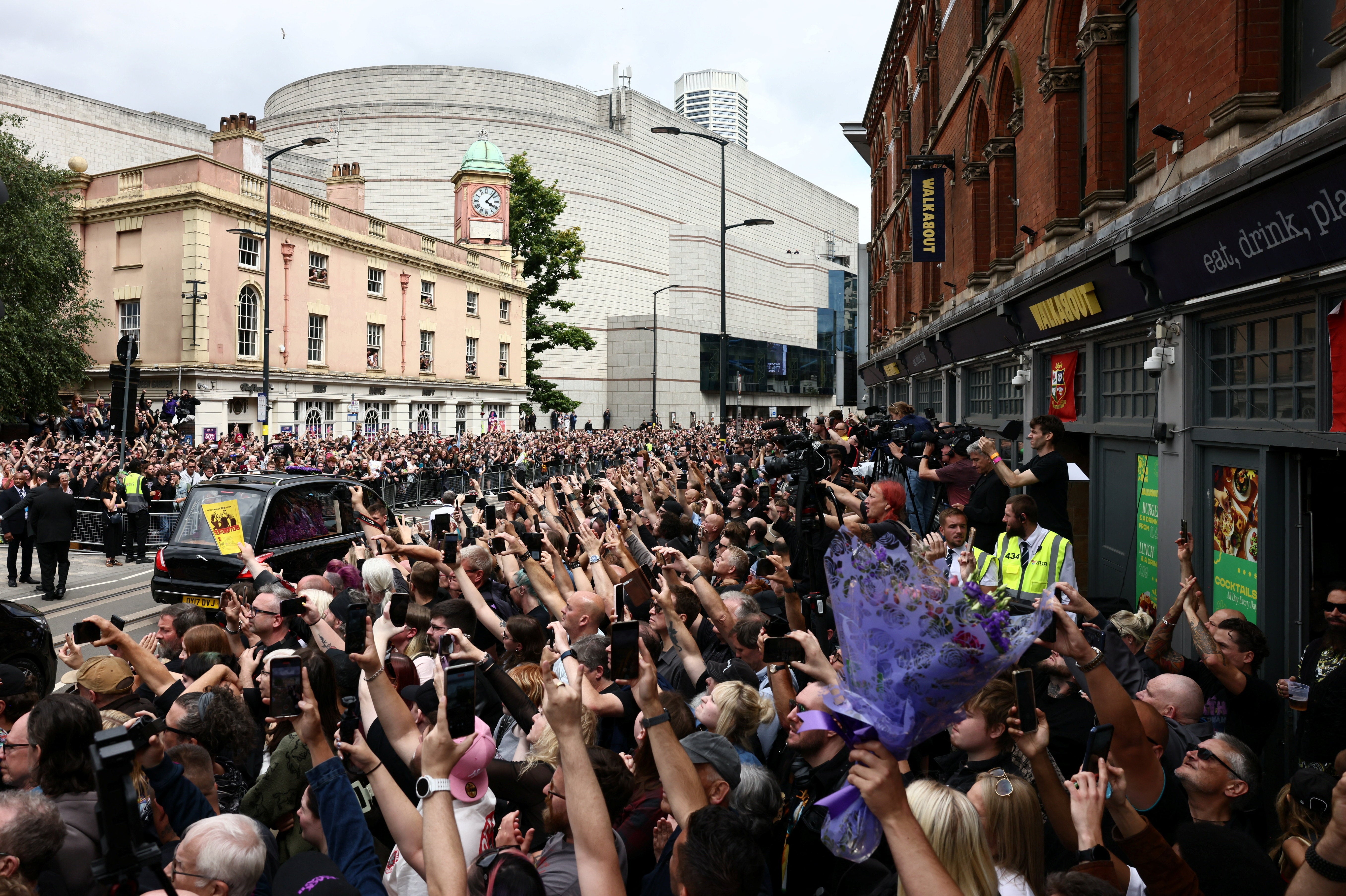 Crowds gather at the Black Sabbath Bridge, named in honour of the heavy metal band, as the funeral cortege of Ozzy Osbourne