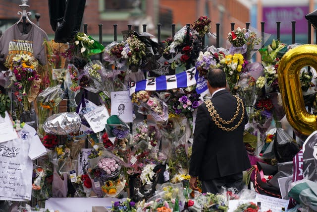 The lord mayor of Birmingham Zafar Iqbal views the messages and floral tributes left at the Black Sabbath Bridge bench on Broad Street in Birmingham in memory of Black Sabbath frontman Ozzy Osbourne (Joe Giddens/PA)