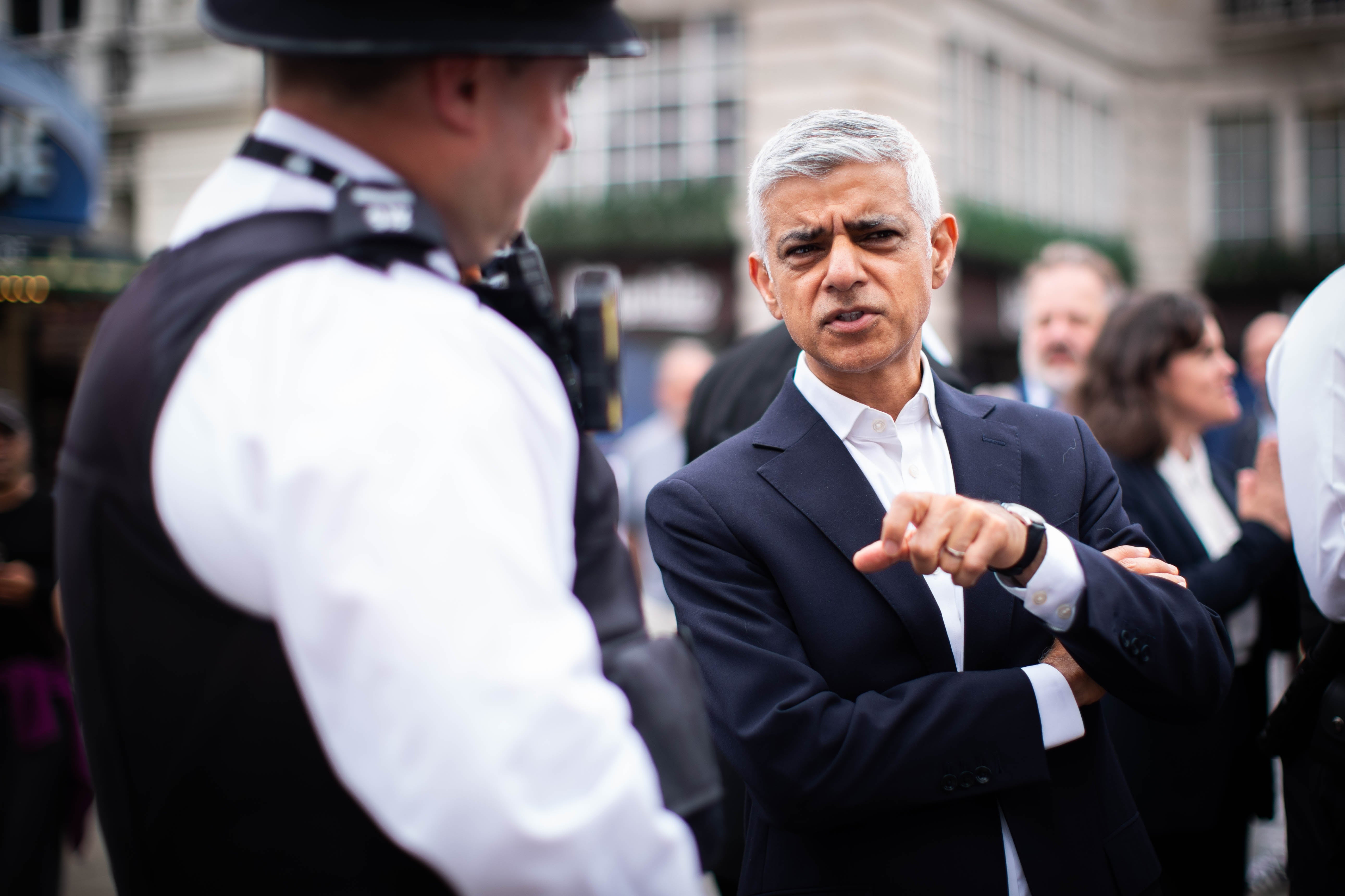 Mayor of London Sir Sadiq Khan speaks with police officers during a walkabout in the West End of London