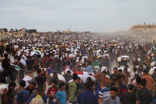 Palestinians carry aid supplies, that entered Gaza on trucks through Israel, in Beit Lahia