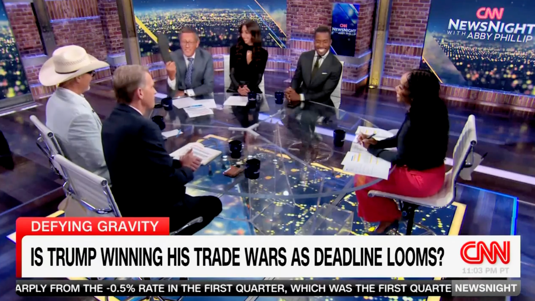 CNN international business correspondent Richard Quest waves his shoe in the air as his fellow panelists watch. Quest took his shoe off during an April CNN panel, citing it as an example of a product that will go up in cost under Trump's tariffs