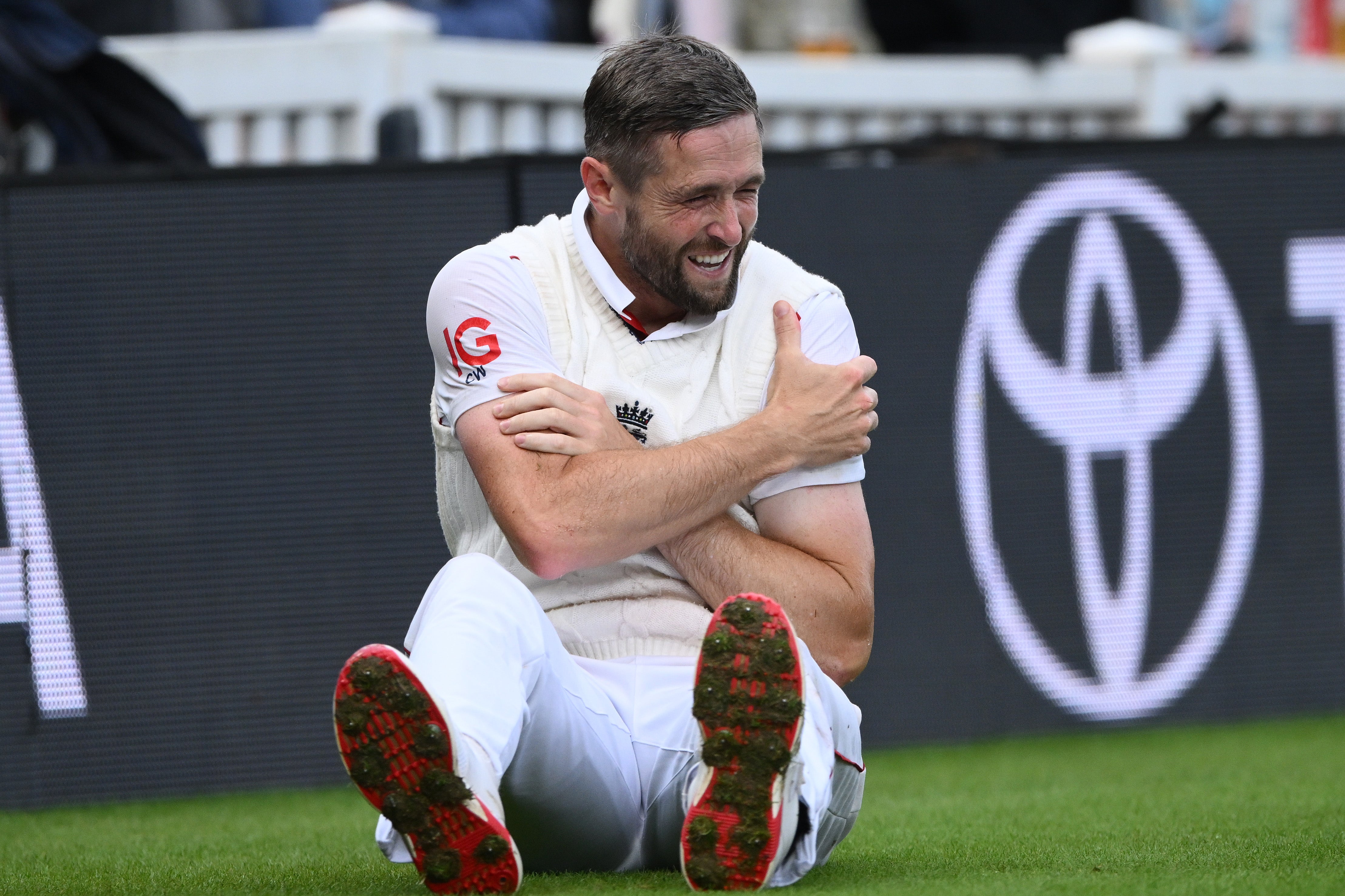 Chris Woakes clutches his shoulder after taking a tumble in the outfield