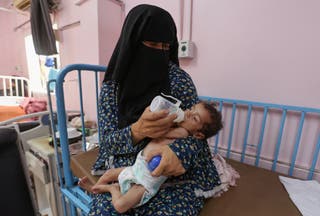 Palestinian woman Najla Abu Aya feeds her five-month-old daughter, Rama, who is malnourished, according to medics, at Nasser Hospital in Khan Younis, southern Gaza Strip