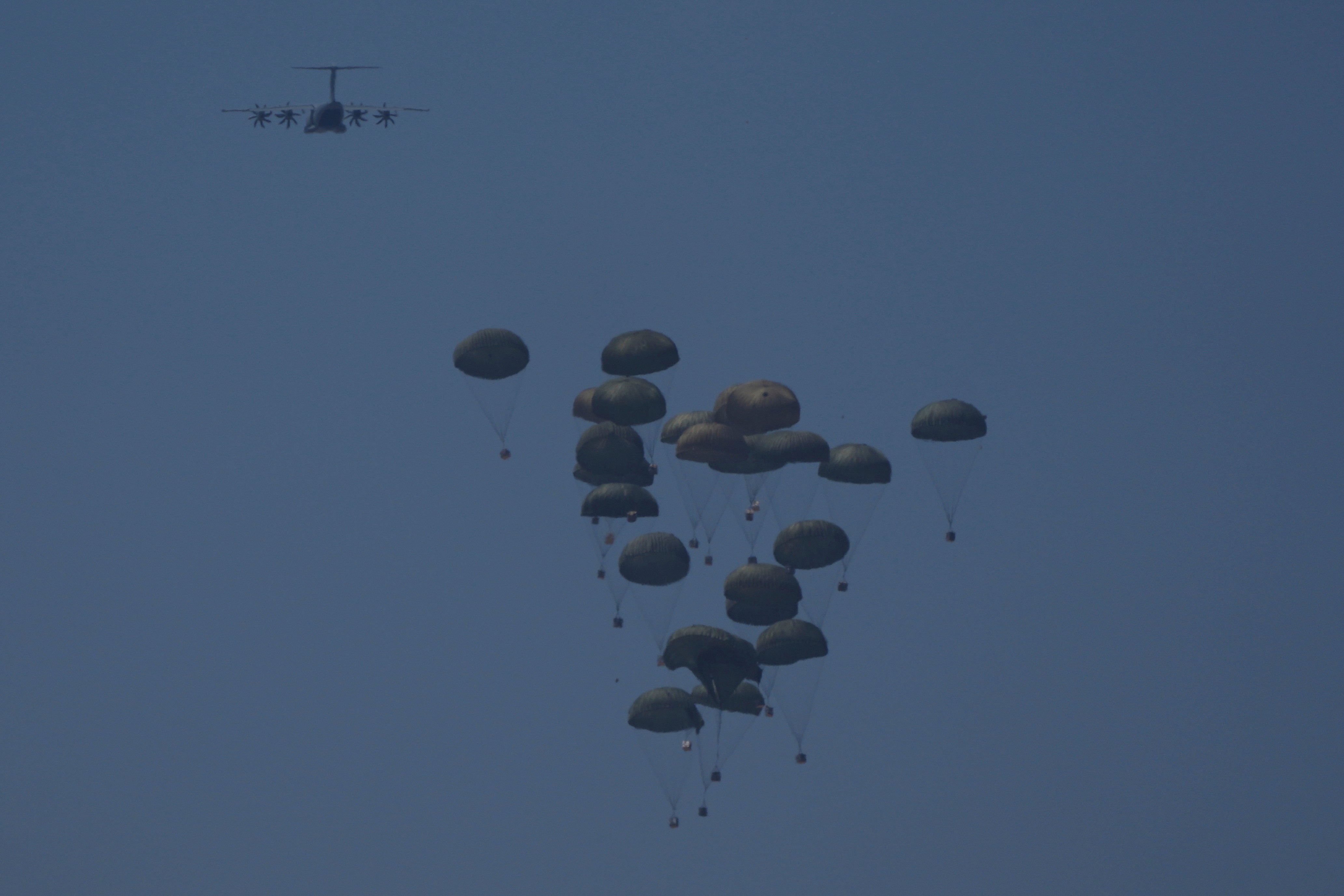 An aircraft airdrops humanitarian aid to Palestinians over Khan Younis, in the Gaza Strip, Friday