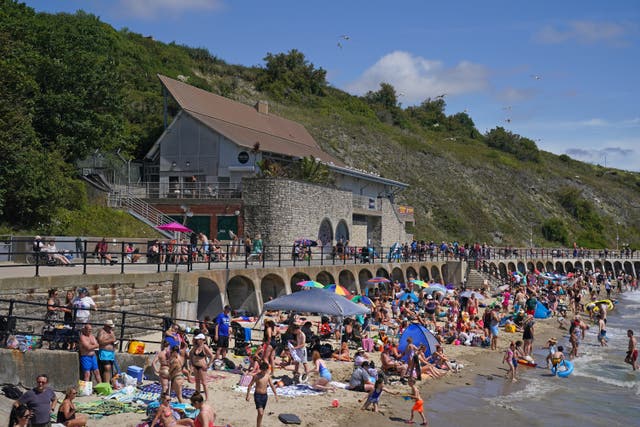 <p>People enjoying the hot weather on Sunny Sands beach in Folkestone, as the third heatwave of the summer hit the UK (Gareth Fuller/PA)</p>