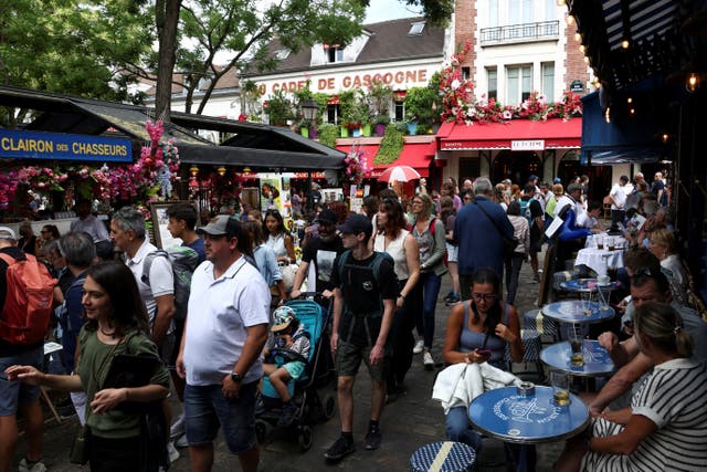 <p>Tourists walk through crowded streets of the Place du Tertre in Montmartre, Paris</p>