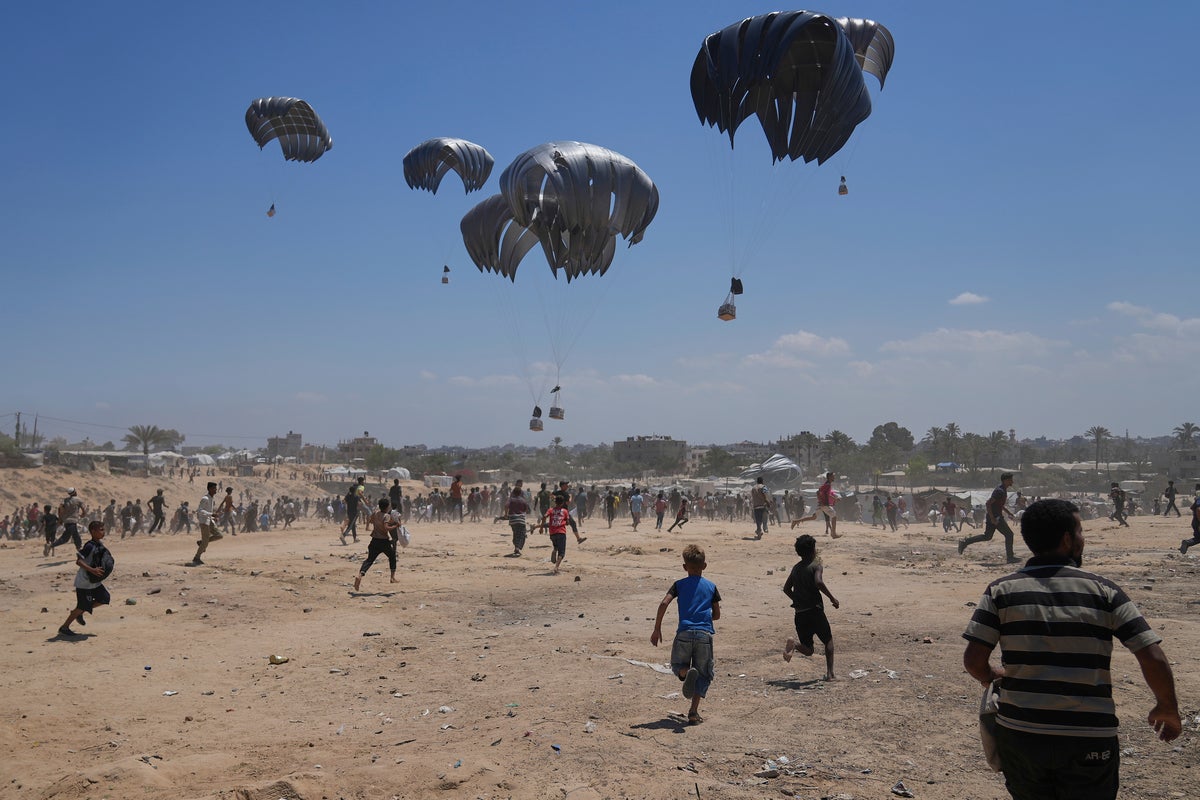 Photos show Palestinians pursuing food aid after the latest air drops in Gaza