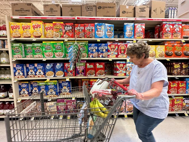 <p>A woman pushes a shopping cart past boxes of Kellogg's breakfast cereal at a supermarket, Friday, July 11, 2025, in Springfield, Pa. (AP Photo/Matt Slocum)</p>