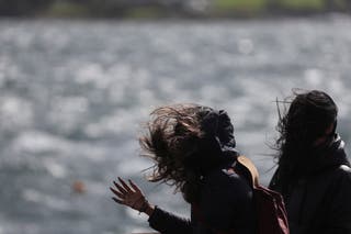 Women walk on the esplanade, as Storm Floris hits Scotland, in Oban