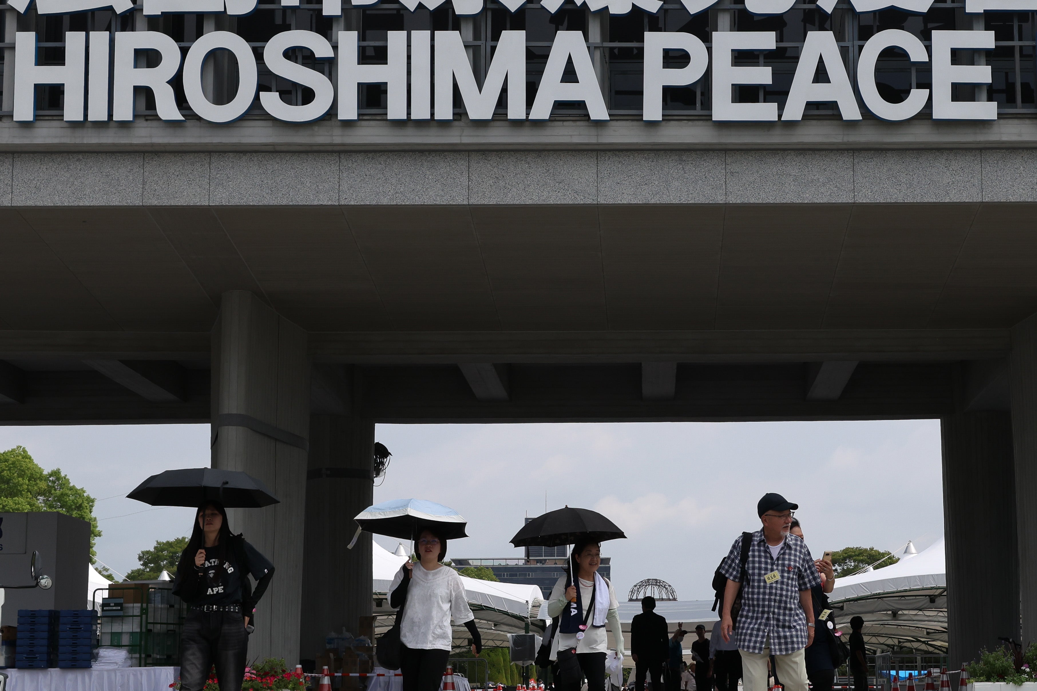 Visitors walk under a sign marking the 80th anniversary of the atomic bomb attack in World War II at the Hiroshima Peace Memorial on 5 August 2025 in Hiroshima, Japan