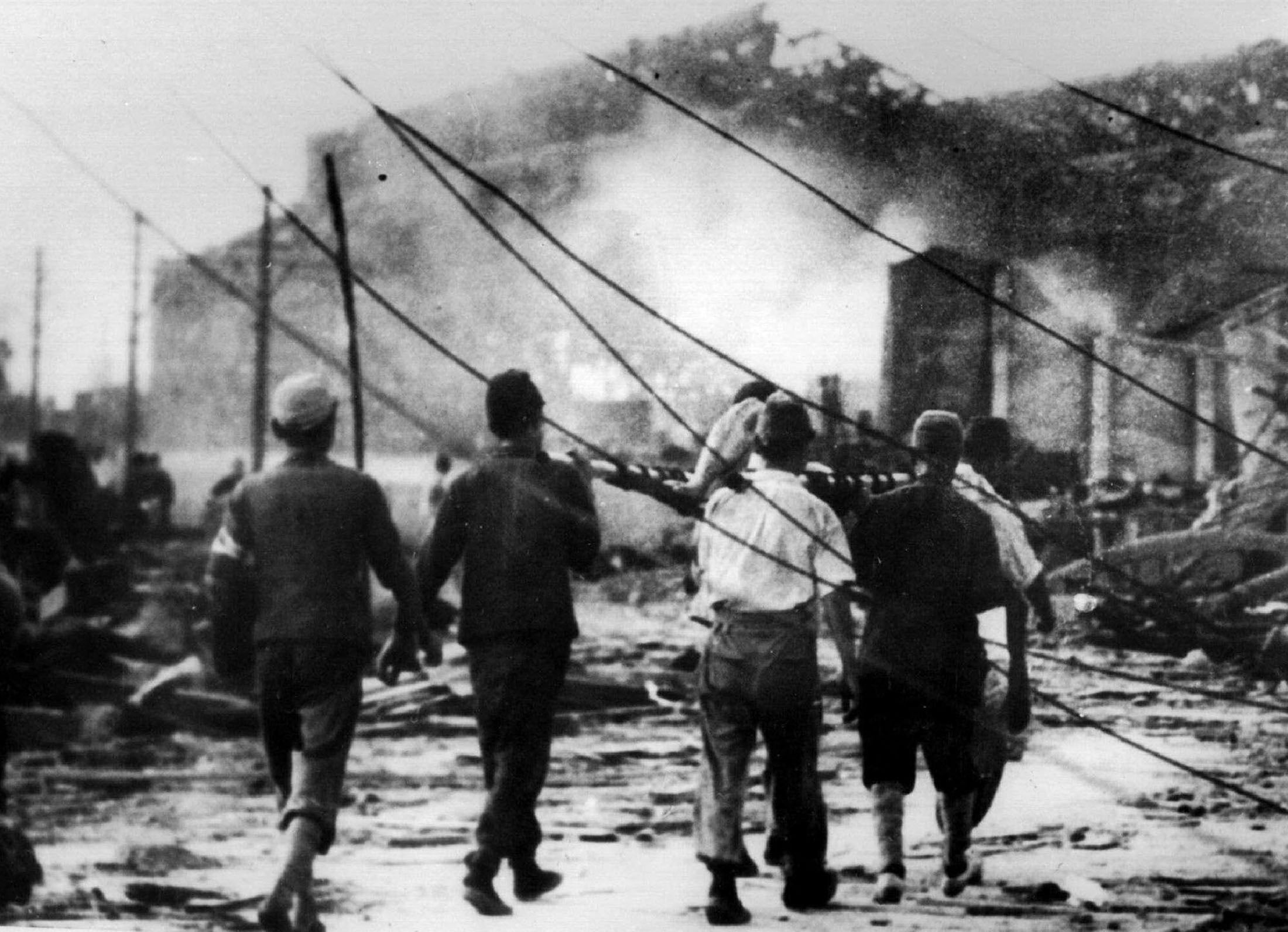 Japanese men carry a victim of the atomic bomb in Nagasaki in August 1945. 6 August 2025 marks the 80th anniversary of the dropping of the first atomic bomb, nicknamed 'Little Boy'. Three days later, on 9 August 1945, the United States dropped a 10,000-pound plutonium 239 bomb, nicknamed 'Fat Man', on Nagasaki