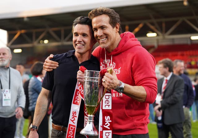 <p>Rob McElhenney and Ryan Reynolds, co-owners of Wrexham, pose with the trophy in April, following the club’s promotion to the Sky Bet Championship</p>