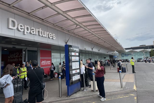 Passengers waiting outside departures at Birmingham Airport (Sophie Robinson/PA)