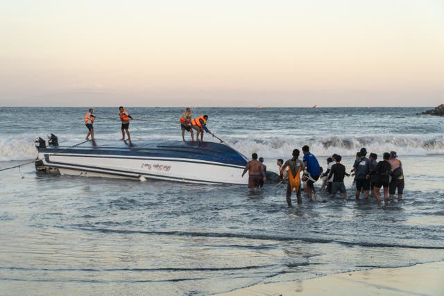 <p>Rescue workers attempt to recover an overturned speedboat after it sank near Sanur port in Bali</p>