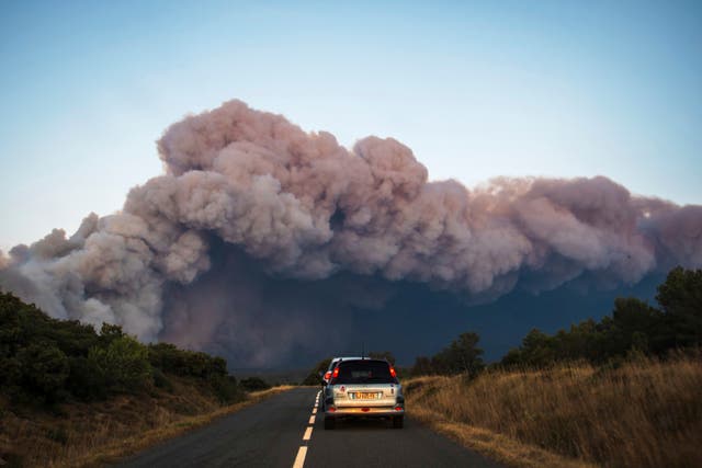 <p>Smoke rises from a fast-moving wildfire close to the border between southern France and Spain </p>