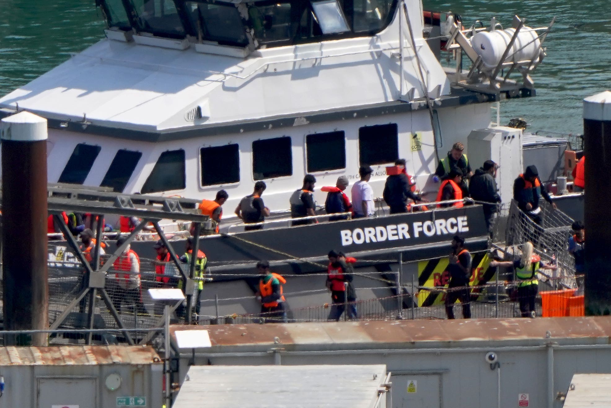 <p>A group of people thought to be migrants are brought in to the Border Force compound in Dover, Kent, from a Border Force vessel </p>