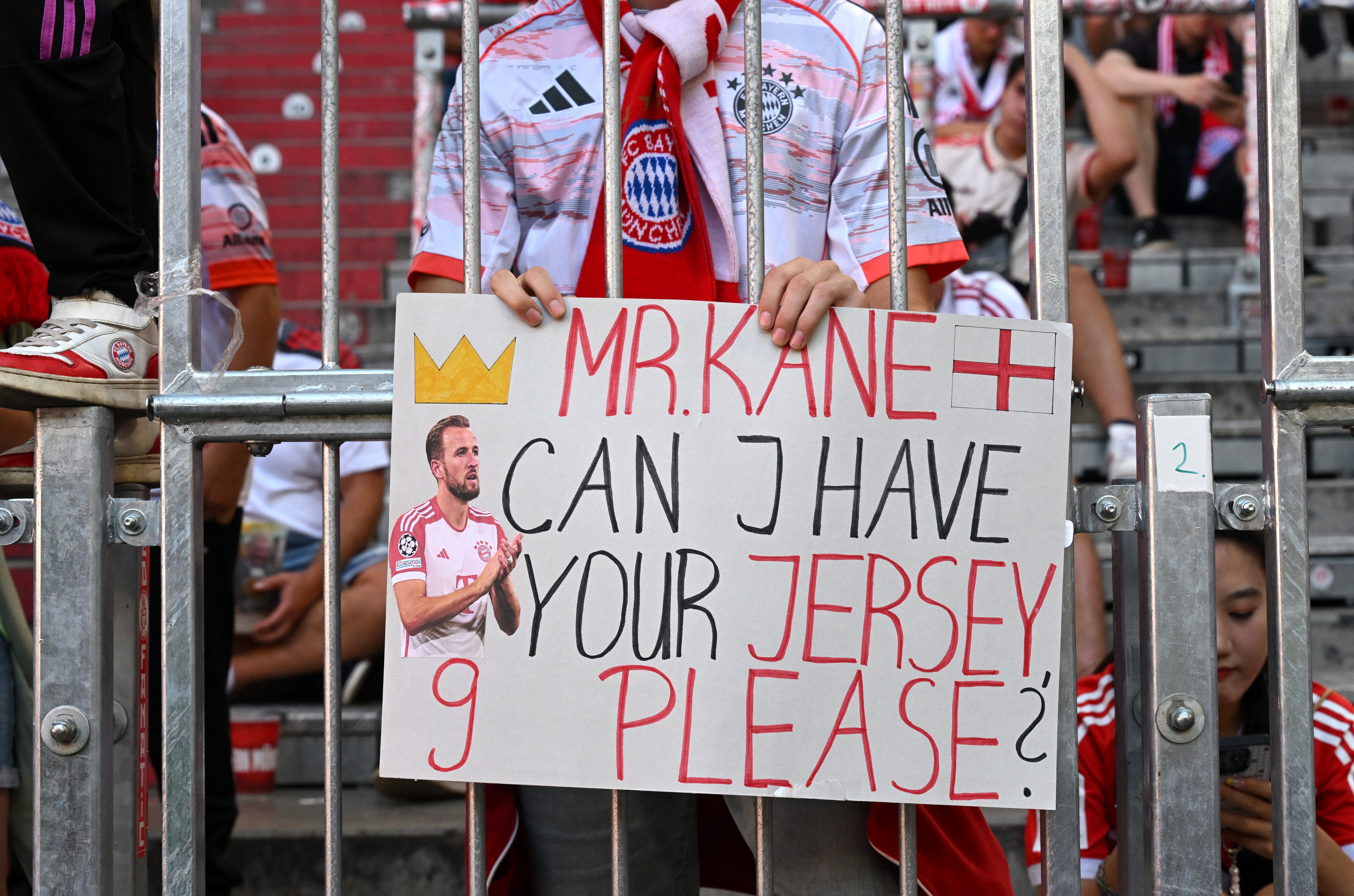 A fans holds a sign Bayern Munich's Harry Kane before the match